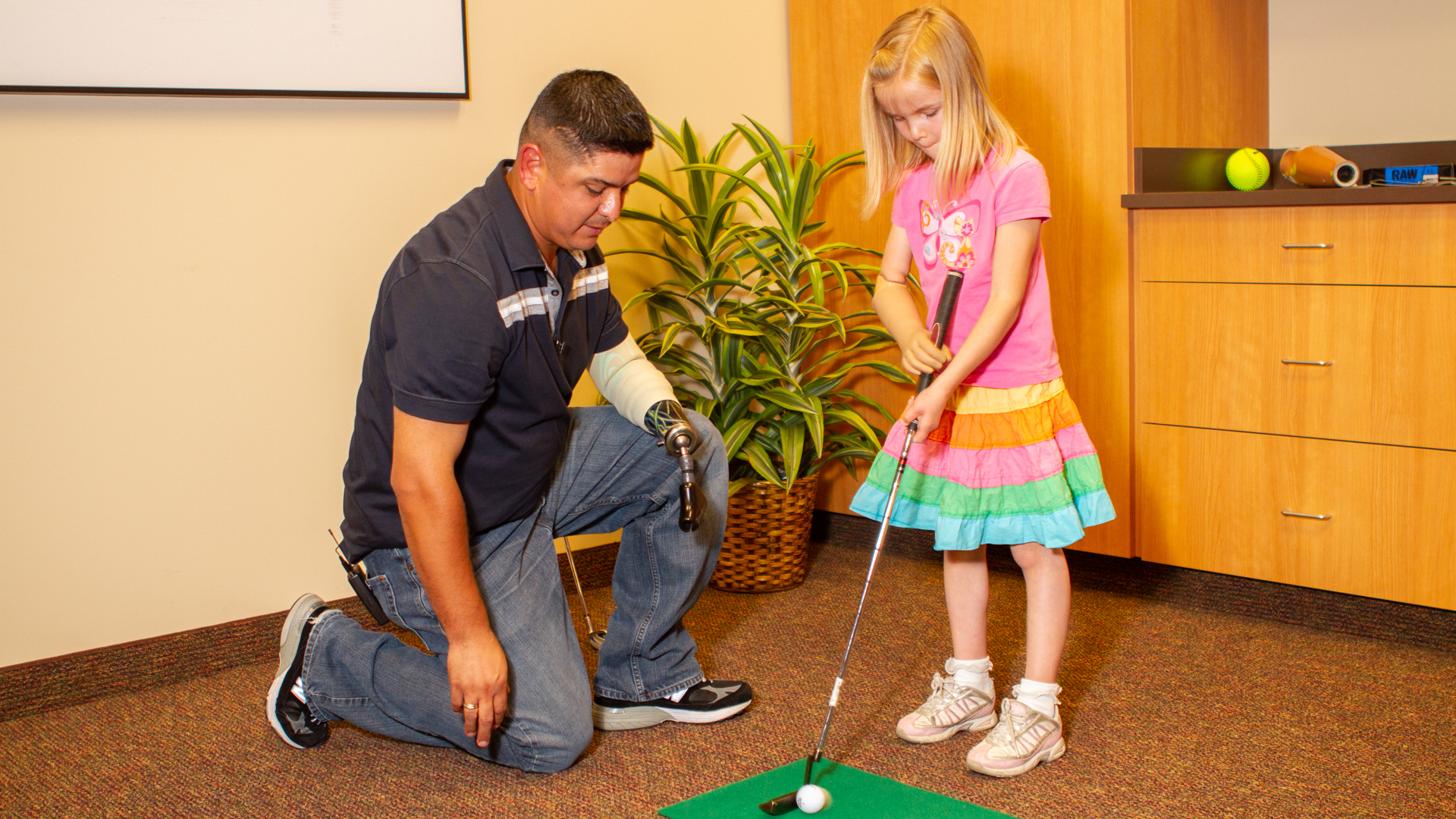 在城里参加一个活动时，拉蒙·帕迪拉和儿科病人安珀·彼得森一起打高尔夫球。
